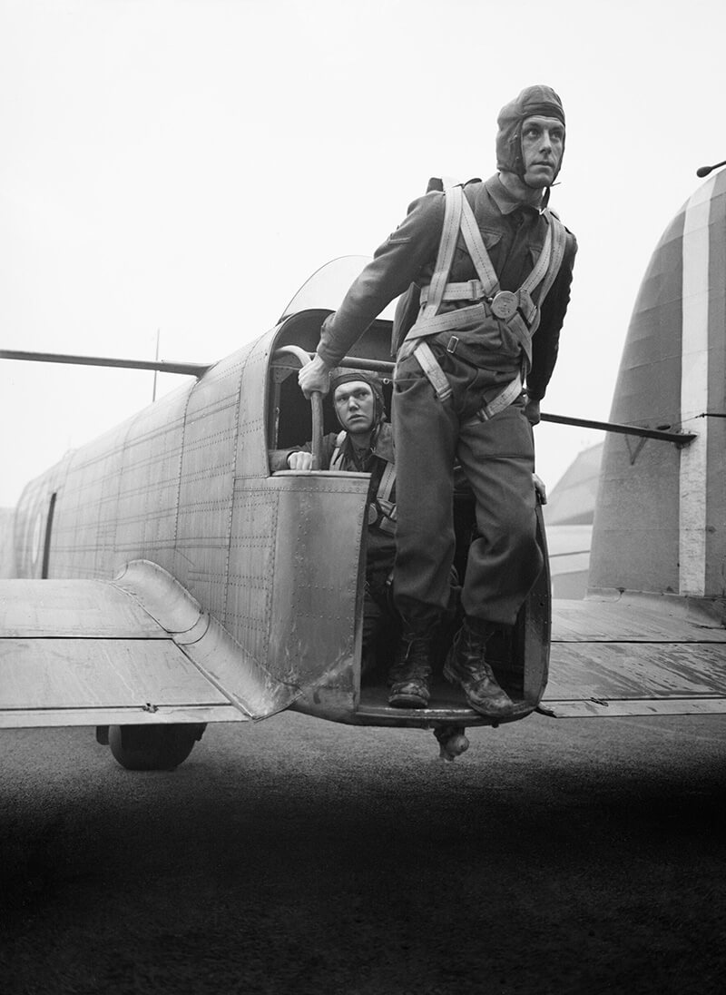 A paratrooper demonstrates the exit point from the tail of a Whitley bomber converted to parachute-dropping, RAF Ringway, January 1941.