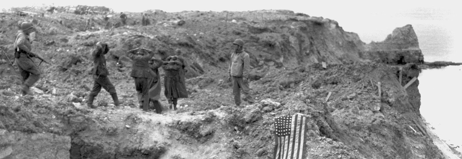 German prisoners escorted from Pointe du Hoc to the beach where boats are waiting to bring them to Great Britain, June 6th, 1944.
