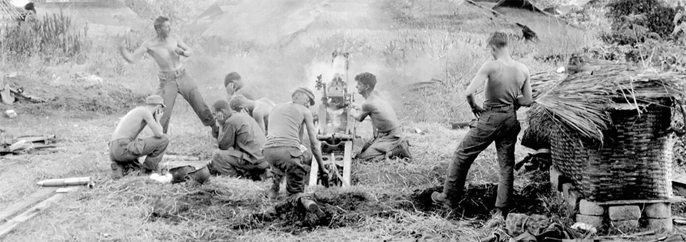 1st Section, C Battery, 612th Field Artillery fires at Japanese positions near the Burma Road, 19 January 1945. Standing at left is SGT George Hasse, while (L to R) PFCs John Elliot and Stan Eddy kneel at the gun trail.