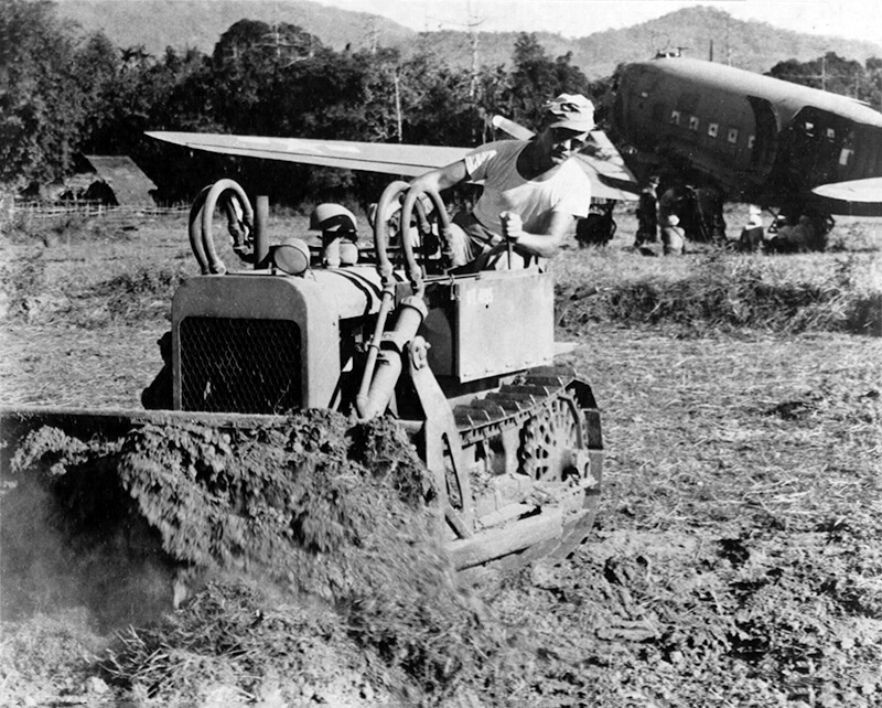 An engineer of the 900th Airborne Engineer Aviation Company clearing the strip with a Clarkair CA-1 bulldozer.