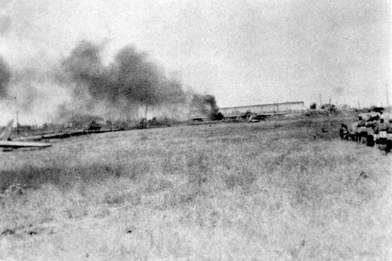 The Primosole Bridge is captured in this southward view, with smoke rising from a nearby area still burning after recent combat. On the left, a BritishAirspeed Horsa glider is visible, having been used during the The Primosole Bridge is captured in this southward view, with smoke rising from a nearby area still burning after recent combat. On the left, a British Airborne glider is visible, having been used during the paratrooper assault to secure this vital objective assault to secure this vital objective.