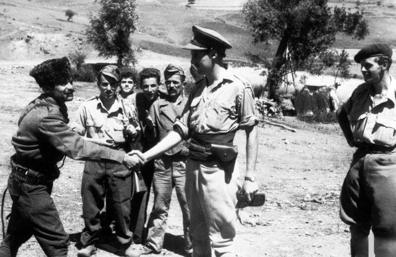 SERVICE OF MAJOR DAVID SMILEY WITH THE SPECIAL OPERATIONS EXECUTIVE (SOE) IN ALBANIA, 1943 - 1944. (HU 65147) Xhelal Staravecke shaking hands with Major Billy McLean at Shtylla, August 1943 during the first SOE mission to Albania. Behind them are Stilian and Stephan and, on the right, Major Peter Kemp. Copyright: ý IWM. Original Source: http://www.iwm.org.uk/collections/item/object/205018789