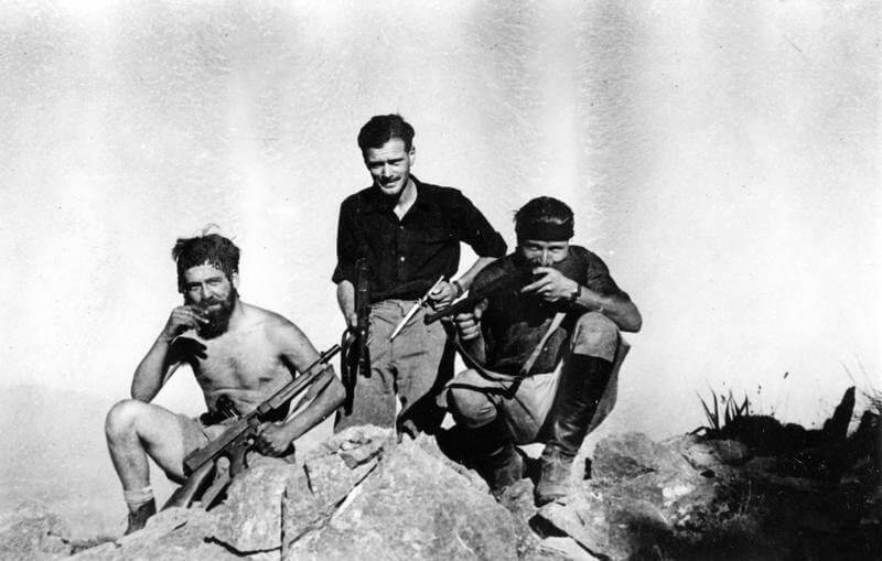 SOE (SPECIAL OPERATIONS EXECUTIVE) AND CRETAN PARTISANS ON CRETE, 1 JUNE 1944 - 28    FEBRUARY 1945. (HU 66047) Two operatives and a partisan pose for the camera in the White Mountains: (left to right); Cpl Steve Gillespie, Lt Cavil Peacock and Pavlos Vernadakis. Copyright: ý IWM. Original Source: http://www.iwm.org.uk/collections/item/object/205045437