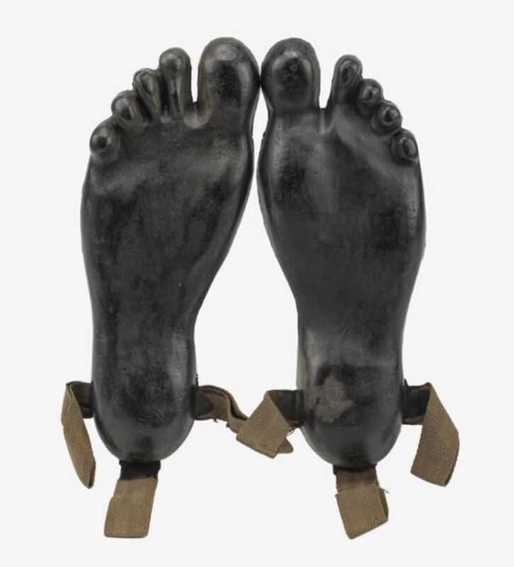 Overshoes, Decoy 'Sneakers': SOE. Pair of matching overshoes made of rubber, cast in the form of bare human feet.  Each 'shoe' has tying tapes for fitting to the wearer's conventional boots/shoes. 