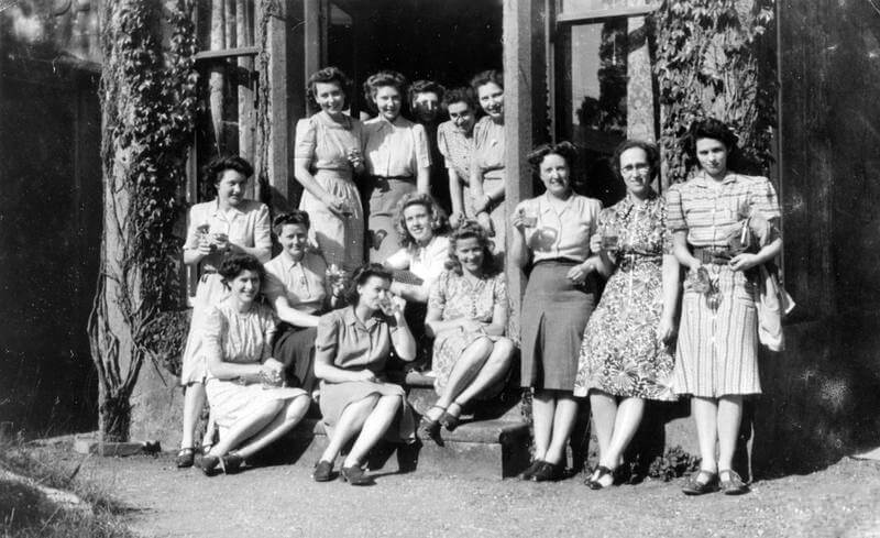 WOMEN OF THE SECRETARIAL STAFF OF STATION XII, THE RESEARCH AND INFORMATION SECTION OF SPECIAL OPERATIONS EXECUTIVE (SOE) 1944 - 1945 (HU 67317) Back row in doorway (left to right):  Gerry Stamper, Joyce Bidgood, Joan Whittle, Kathleen Skuse, Christine Watson; front row in doorway (l-r);  Pat Spillman, Mary Romset, Mrs Wenman, Dorothy Packman, Pam Ashley, Olive Taylor; standing to right of doorway (l-r):  Pat Dicks, Evelyn Amner, Jean Holmes-Kerr. Copyright: ý IWM. Original Source: http://www.iwm.org.uk/collections/item/object/205040045