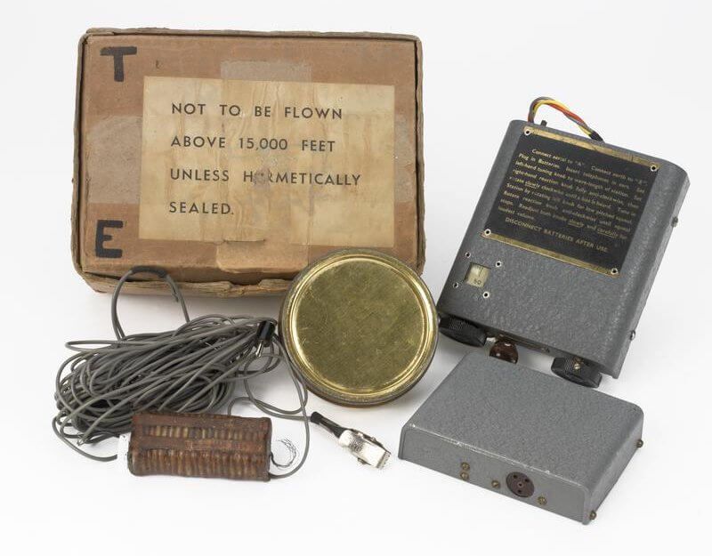 Wireless Equipment, 'Sweetheart' Miniature Receiver Type 31/1, British (COM 554) Cardboard Box 4 (Brown Plastic block, Circular metal tin, 2 Grey boxes and grey wire):
Cardboard Box: Has self adhesive tape along the edges of the box and there is a label on the top of the box saying 'NOT TO BE FLOWN ABOVE 15,000 FEET UNLESS H-METICALLY SEALED' (Some letters missing).
1)	A small rectangular box that has been coated in a brown rubber substance and on either side there are wire at... Copyright: ý IWM. Original Source: http://www.iwm.org.uk/collections/item/object/30005785