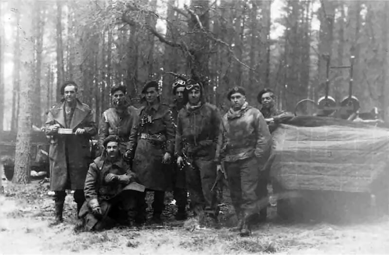 A patrol of 1 Special Air Service photographed somewhere in Germany, likely during the final weeks of the war in April or early May 1945. The men stand beside their well-worn jeeps, armed and ready for rapid movement.
Of particular interest is the soldier on the far right, clearly wearing the distinctive SAS cap badge on his sand-coloured beret. The man standing next to him, however, appears to wear the badge of the Royal Tank Corps.