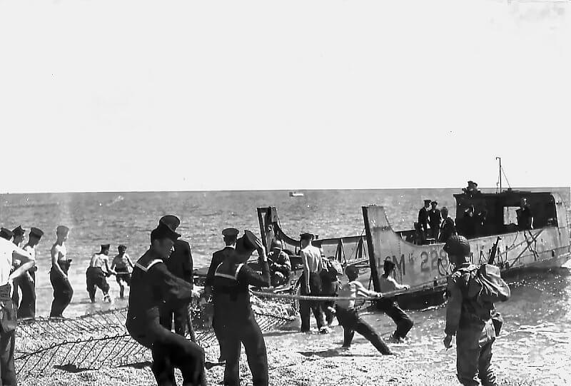 A Landing Craft Mechanised is stabilised by British Royal Navy sailors at Slapton Sands.