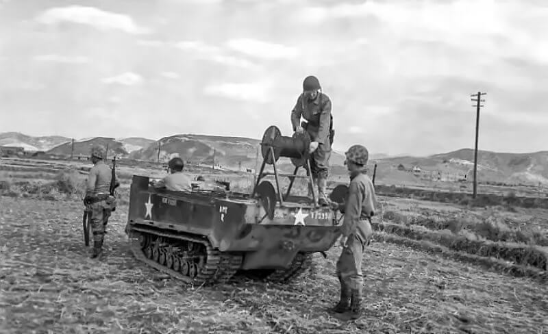 A Studebaker Weasel from the First Marine Division’s communications section lays telephone wire across flooded rice paddies under combat conditions.