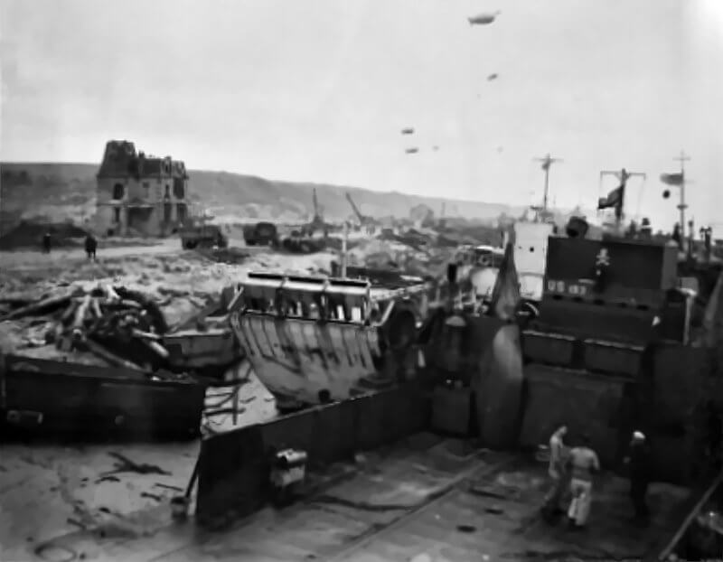 Severe storm hampers beach operations at WN66, with ships dragging anchor and driven ashore despite the breakwater.