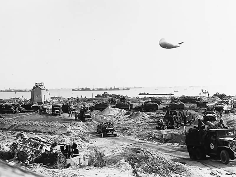 Days after D-Day at WN66, blockships lie offshore as traffic builds up and struggles to clear the beach.