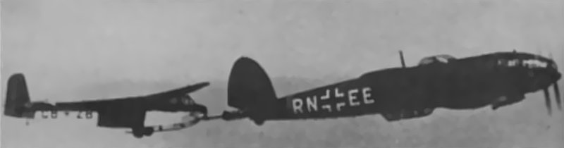 A rigid towing system is developed to provide more stable towing. It performs well in trials and service. It is not widely adopted. It requires a Heinkel He 111 as the tug. These aircraft are needed for other tasks.