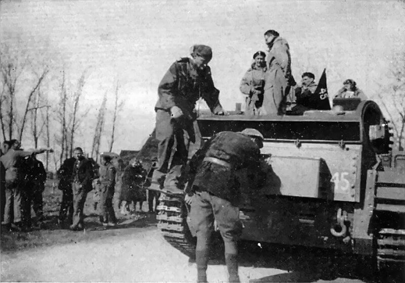 April 10th, 1945, Witteveen. Polish Cromwell tanks arrive by mid-morning. Major Puech-Samson descends from the rear deck of a Cromwell after consulting the tank commander, as a villager chalks a message on the hull.