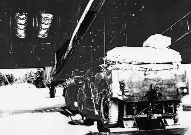 The bomb bay doors of Halifax Mk III and Mk V bombers, and some Short Stirlings, are removed to accommodate parachute-equipped jeeps.