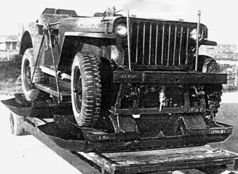 The assemblies rest on a removable lightweight sheet-metal plate covering the jeep’s rear, clearly visible on the right of the upper photograph.